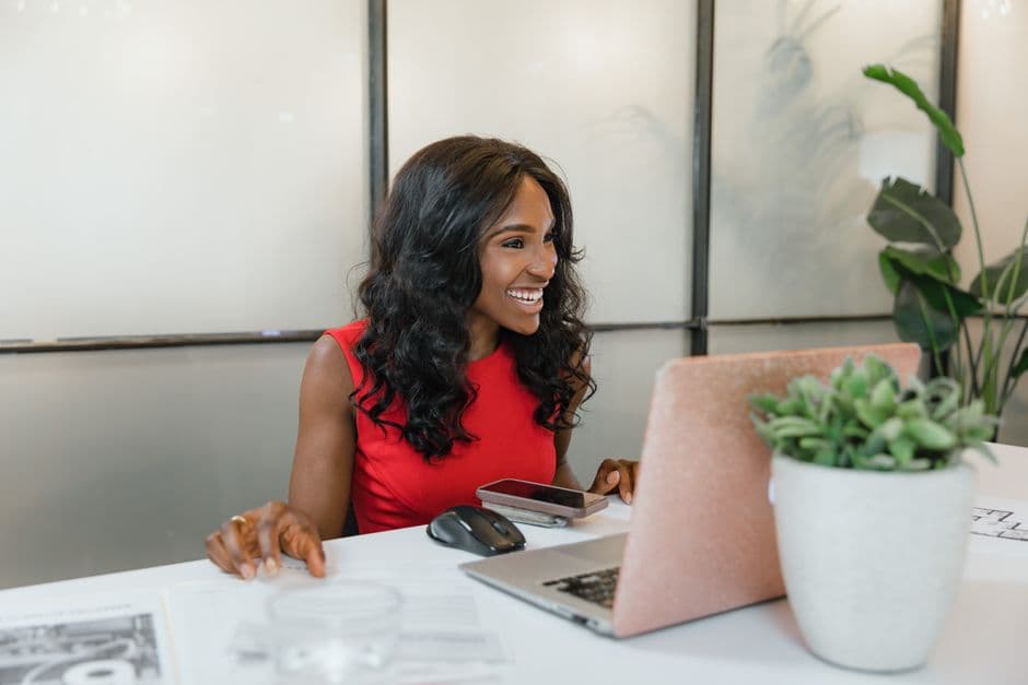 Business owner smiling at her laptop in an office